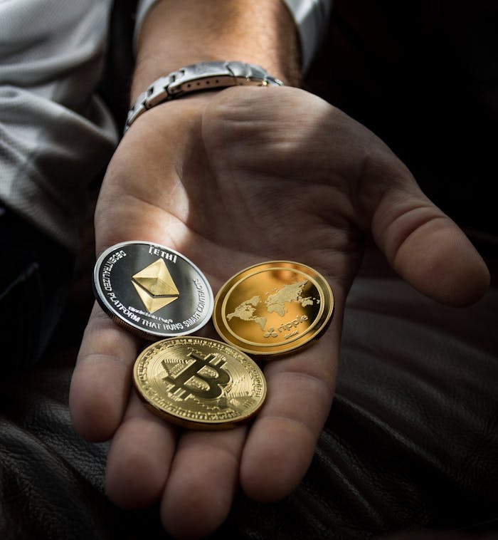 OLE777 Hand holding Bitcoin, Ethereum, and Ripple coins representing digital currency.